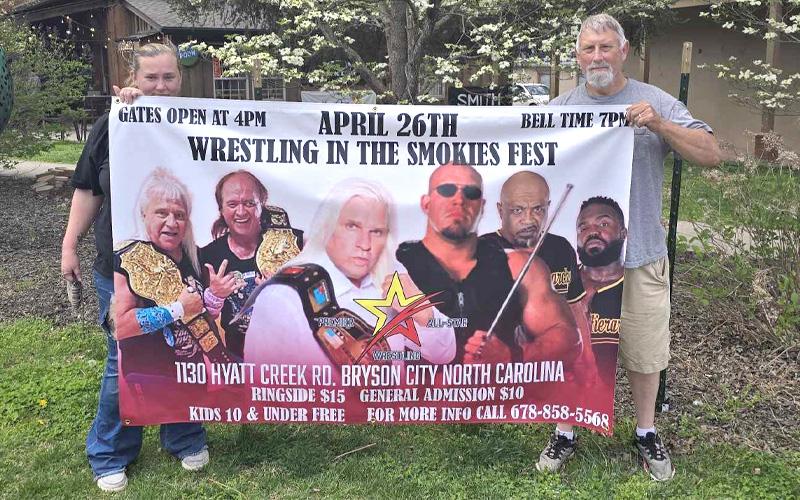 SMT photo/ Sara Eisinger.  Jamie Bagley and Billy Bagley aka Billy Knight ‘Dixie Dynamite’ hang Wrestling in the Smokies Fest banner at the corner of Everett and Main Street April 5. Great Smoky Mountains Event Park will host professional wrestlers from around the world.