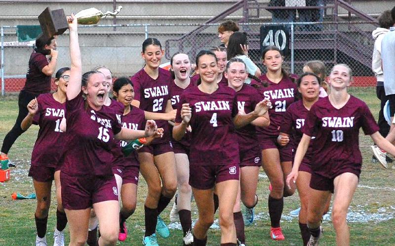 Submitted photo.  Karena Cline carries the Smoky Mountain Conference trophy alongside teammates after winning the conference championship Monday. The Lady Devils completed an undefeated season in SMC play, improving to 12-0 in the conference and 15-1 overall.