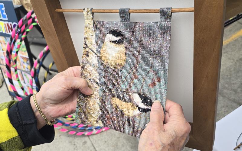 SMT photo/Sara Eisinger.  Joan Stocker of Beubelot Beading displays a black capped chickadee made from 17,026 beads from her vendor booth at Heritage Festival in Bryson City Saturday afternoon. Stocker’s favorite thing about bead art is being able to touch it.