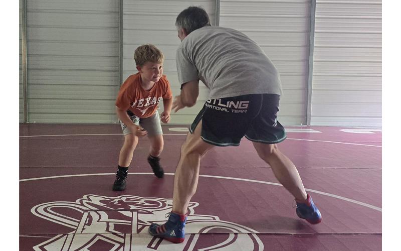SMT photo/Sara Eisinger. Owen Best wrestles with Coach DeHart at DeHart Wresting Academy in Bryson City June 28. DeHart coaches individuals, groups, camps and more.