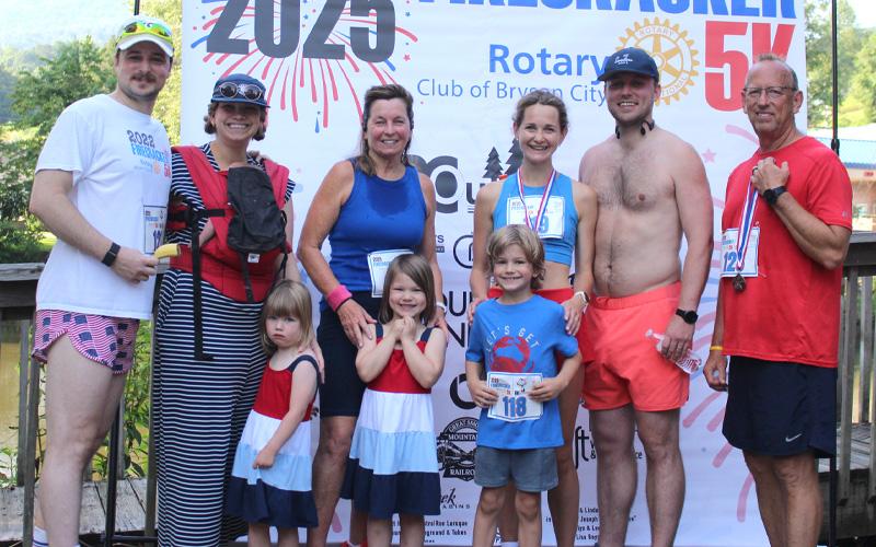 Photos/Deb Stuart.   The Couch Family (front, left to right), Eloise, Birdy, Henry; (back, left to right), Jarrod, Alyssa, baby Margot, Judy, Annie, Jordan and Gene at the 2025 Firecracker 5K in Bryson City on July 4. Judy Couch has run this race for 35 of the 36 years it has been held.