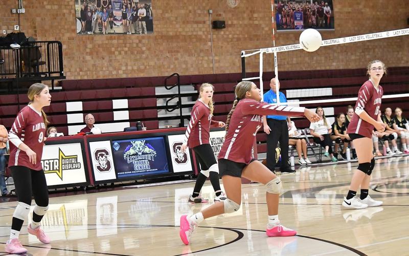 JV freshman, Charleigh Loftis (7) back sets the ball for her right side attacker.