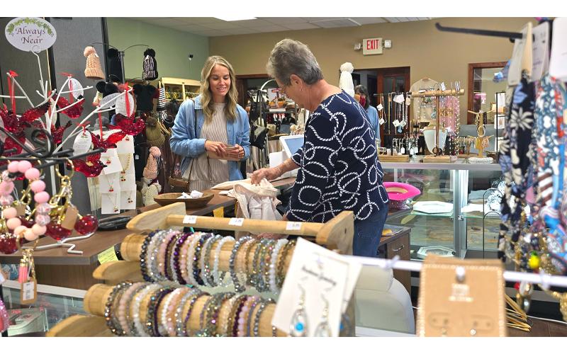 SMT photo/Sara Eisinger.  Joan Bailey sells customer Leah Frazier apparel at Pursenality Marketplace Oct. 11.