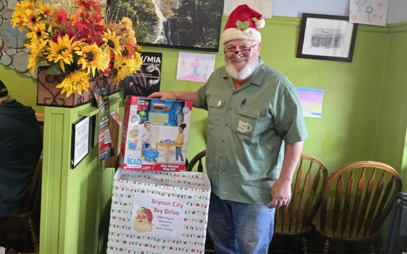 SMT photo/Sara Eisinger.  Mike Shakar, owner at Everett Street Diner, collects Christmas gifts in partnership with Swain County Family Resource Center Dec. 1