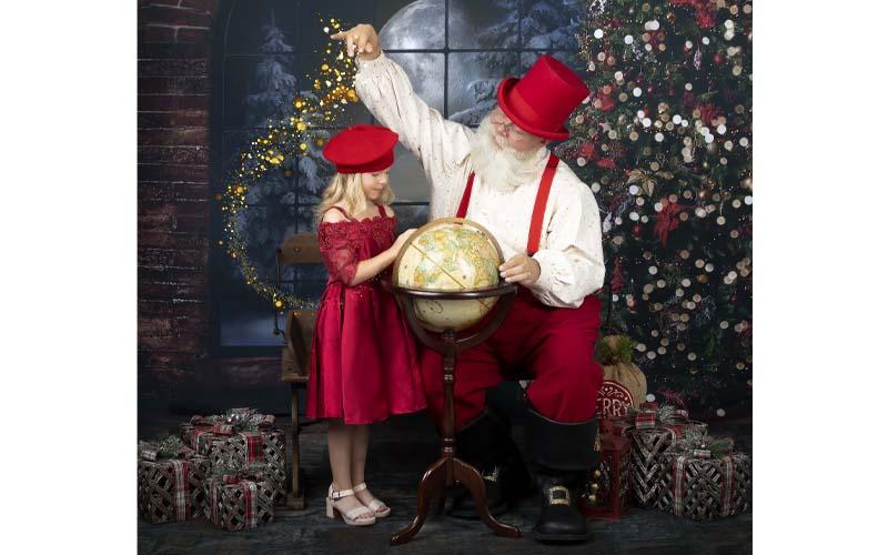 Photo/ Michelle Cochran.  Ellie Hatton poses with Santa Claus aka Tim Marks at Portraits by Michelle this Aug.