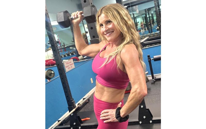 SMT photo/Sara Eisinger.  BiBi Pride, owner at Bryson City Health &amp; Fitness Center, flexes after 10 months of incorporating weightlifting into her workout regimen Dec. 29.