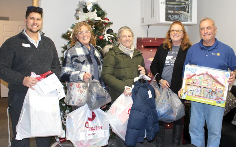 Submitted photo.  Tristen Packer (left to right), Deb Stuart, Antionette Prisco, Anne Herzog and Nick Nichols, members of Rotary Club of Bryson City congregate in front of the Family Resource Center’s Christmas tree in December 2025.