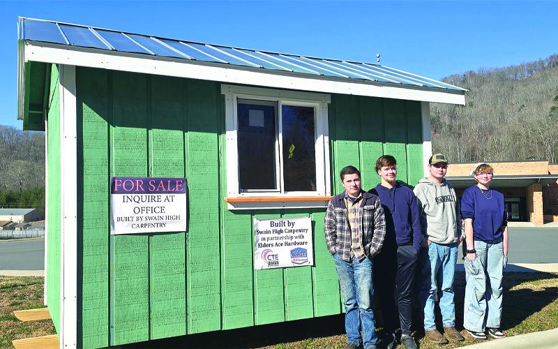 SMT photo/Sara Eisinger.  First semester Carpentry I students Damien Ward (left to right), Jon Stephenson, Ted Sutherland and Kenzie Royce stand outside the 12-by-8-foot wooden shed they helped built this year on Jan. 27.