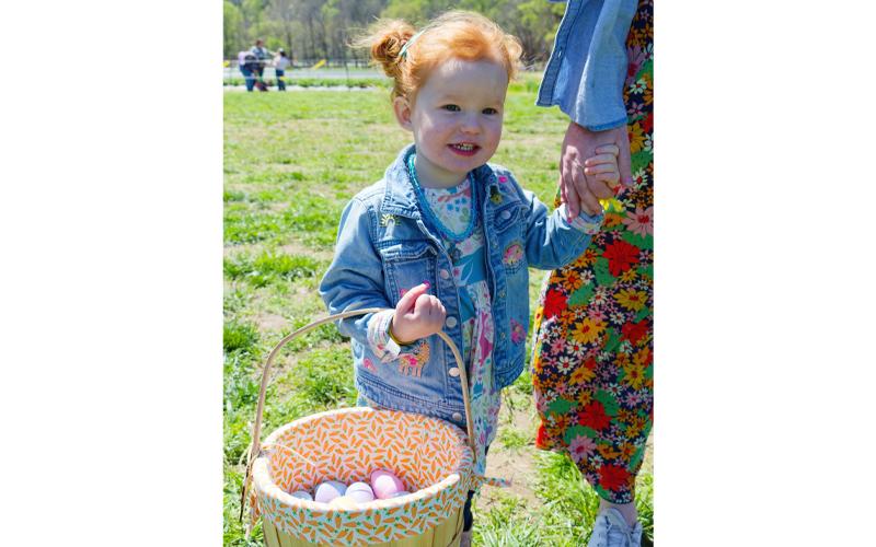 Photo/George Musil.  Little girl proudly holds the bucket of Easter eggs she found at Darnell Farms April 12, 2025.