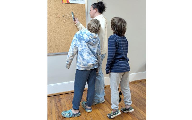 Photo/Amber Johnston. Volunteer Leader Lauren Wagonner teaches the perception of ordinary objects using thumbtacks and shadows during the Explore 4-H: Photography Workshop Feb. 26.