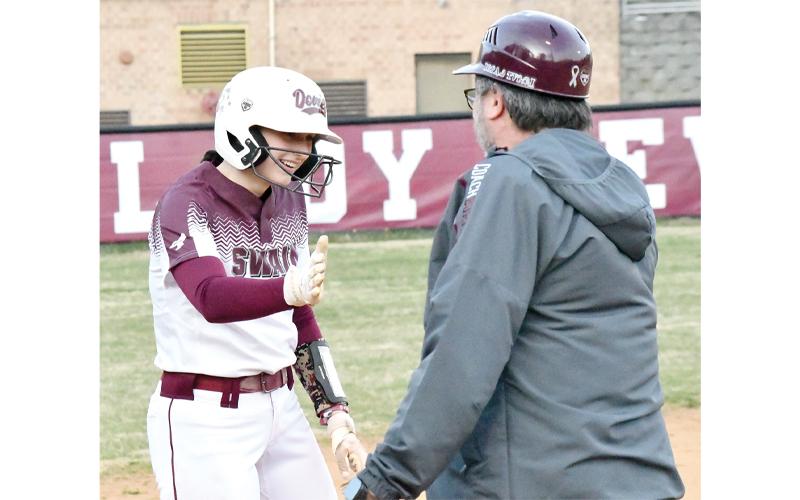 Photo/Joanna McMahan.  Senior Carly Teesateskie receives congratulations by head coach Toby Burrell after a triple on the Devil’s diamond March 4.