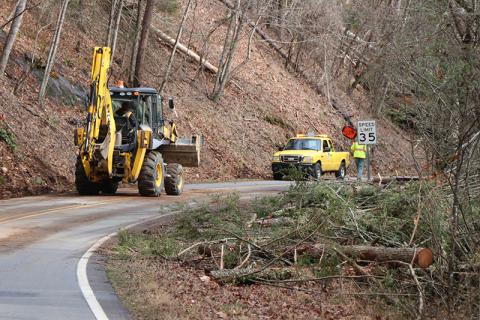 Workers with North Carolina Department of Transportation conduct storm damage clean up in the Grassy Branch community on Monday