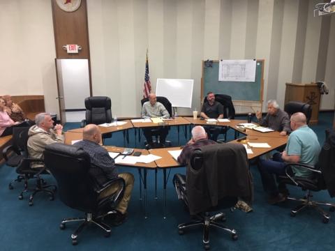 Commissioners meet around a round table to hear from department heads