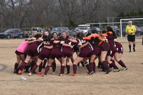 The Lady Devils soccer team has a huddle