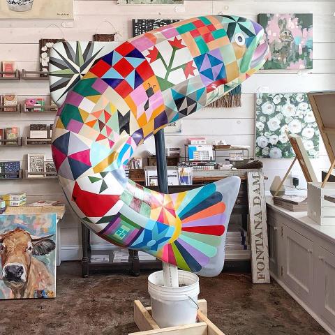 Ashley Hackshaw of Bryson City recently completed painting this trout statue with its detailed quilt pattern. The statue is one of the new statues paid for the TDA. 