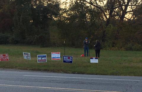 Democrats work to put up a large political sign across from Ingles