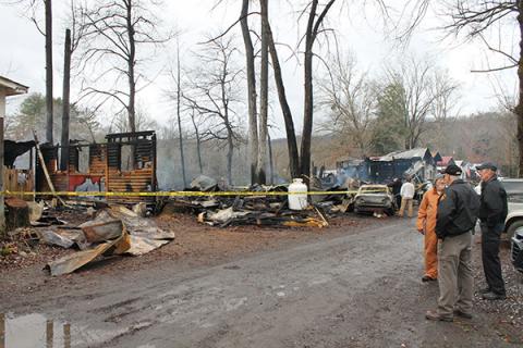 Fire investigators speak with the manager in front of two of the units that were a total loss
