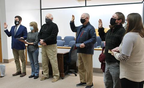Gerald McKinney (incumbent, center), Mitchell Carson (right) and Cody White (left) took their oaths joined by members of their families