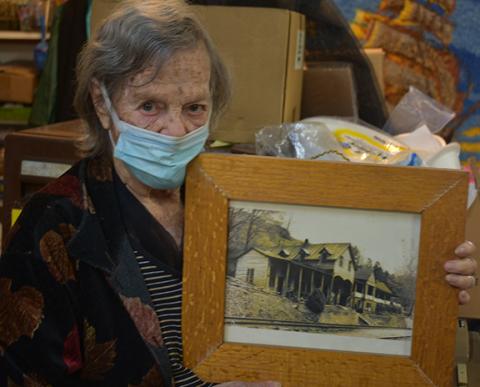 Juanita Lester holds a framed picture of her childhood home that was in the Bushnell community, one of several lost to the formation of Fontana Lake.