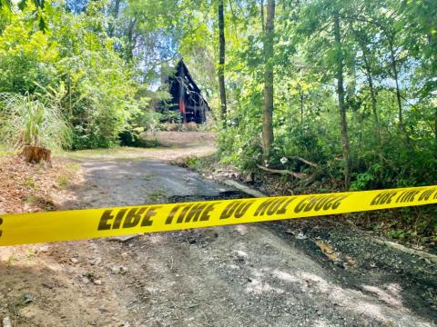 Crime tape blocks off the driveway to a house that was fully engulfed in flames in the early morning hours of June 1. Responders found a body inside the home after the fire was under control. 