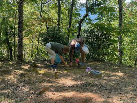 Karen Marcus and Henry Chambers place flowers on a grave
