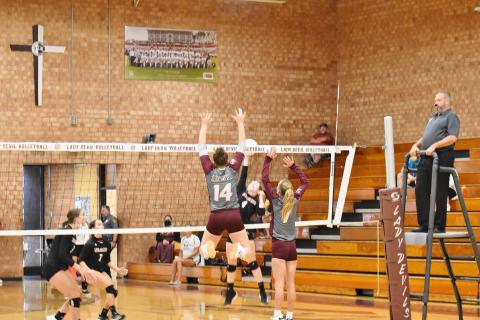 Lady Maroon Devils Savana Smith and Arizona Blankenship block an Andrews spike in the home loss against the Wildcats Thursday. 