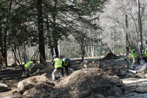 Lead Ranger Adam Monroe and volunteers move debris out of a freshly excavated site at Smokemont Campground during a recent Smokies Service Day.