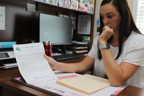 Lisa Stolzfus Loftis, State of Franklin director, holds up a filled-out letter from a client. Every client who was receiving home delivery meals who no longer qualified once Covid relief funding dried up was sent such a letter last summer. 