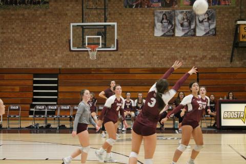 Lady Devil Kiersten Smith sets the ball as her teammates Haileigh Woodard and Rylee Rawls get ready for a spike.