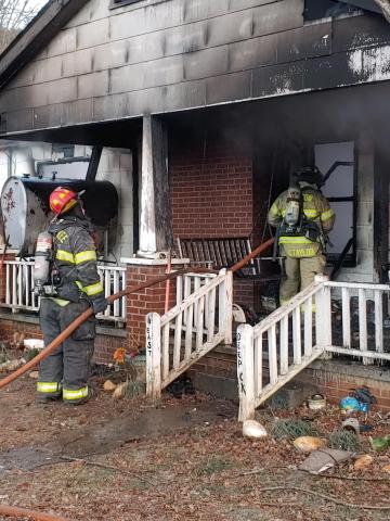 Volunteer firefighters work on a house fire in Deep Creek on Christmas Eve. 