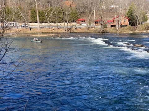A fishing boat floats on the Tuckasegee River near the Governor's Island bridge.