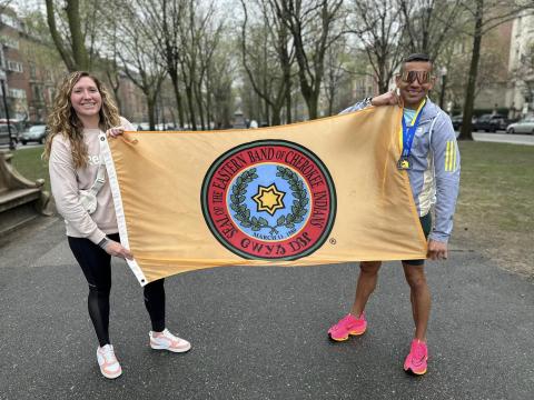 From left, Katelynn Ledford-McCoy and Kallup McCoy hold up the Eastern Band of Cherokee Indians flag while visiting Boston for the 127th Boston Marathon.
