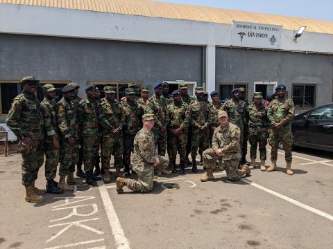 Ghana Armed Forces Brig. Gen. Nii Adjah Obodai, commander, 37th Military Hospital in Accra, Ghana, presents U.S. Air Force Tech. Sgt. Daniel Fisher, Defense Medical Readiness Institute’s Academic Support Branch noncommissioned-officer-in-charge, with a gift of appreciation for establishing a tactical combat casualty care training site in March 2022. (Courtesy photo)