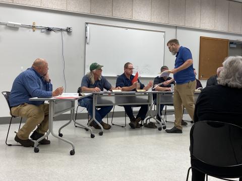 Keith Blane, of Sylva, hands out copies of a book he and others wanted moved to the adult section at the library in Cashiers. 