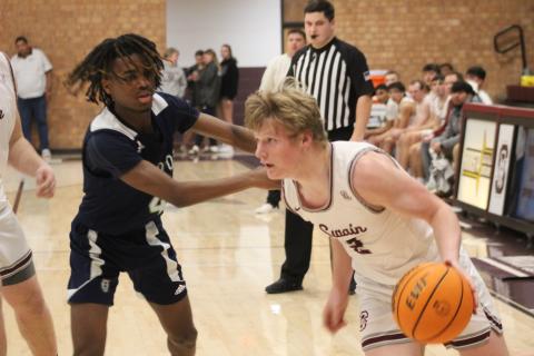 Senior Josh Collins maneuvers the ball around an opponent’s tenacious defense. 