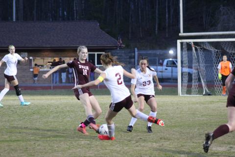 Junior Mya Burrows-Kurr tussles with opponents from Thomas Jefferson Classical Academy at the game Thursday, March 7, which the Lady Devils lost 3-2 in a tight game.
