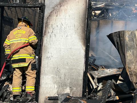 A Bryson City Fire Department firefighter works on a structure fire last week. Fire Chief Charles Bryson wants to staff the department to have someone at the station 24/7. 