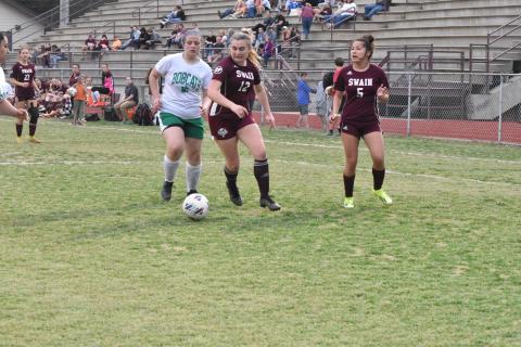 Junior Lola Collins (center) fights for the ball at the soccer game Tuesday, April 2 against Blue Ridge.