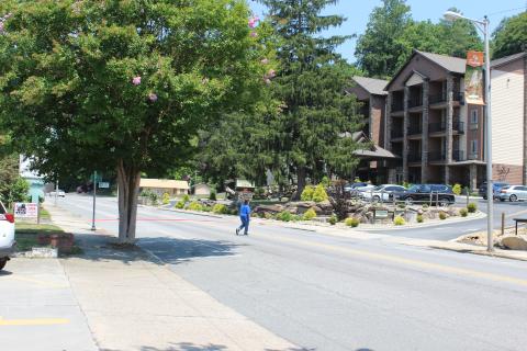 A pedestrian crosses Main Street toward Stonebrook Lodge. The Bryson City Planning Board has identified this section of Main Street as the best area to direct limited grant funding toward sidewalk repairs, in part because most of the utilities under the sidewalks have been upgraded unlike on the other side of the road toward Veterans Boulevard.