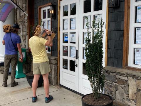 Swain County visitors look at listings posted on the windows and doors at Good Life Real Estate located on Everett Street in downtown Bryson City. 