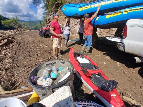 Volunteers unload rafts to put in the water to continue collecting trash and debris. 