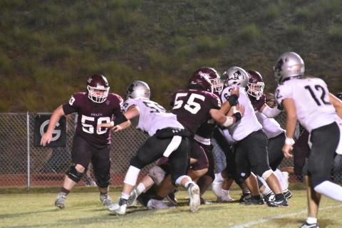 From left, Maroon Devil defense Noah Brown (50) and Drew Scaggs (55) slow the Black Knights down during the home game this past Friday.