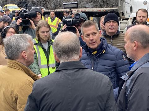 Clockwise from center, USDOT Secretary Duffy speaks with Secretary Joey Hopkins, US Senator Thom Tillis and NC Governor Josh Stein during an event hosted along I-40 Monday to share the progress on repairing the major road after areas were wiped out during Hurricane Helene.