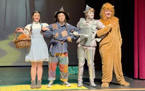 Photo/Rosemary Pearl Moore.  Cassie Fortner as Dorothy, Scout Claxton as Scarecrow, Myles Taylor as Tin Man and Hunter Smith as Cowardly Lion stand arm-in-arm on their way to Oz during a ‘Wizard of Oz’ rehearsal at Swain Arts Center Friday, March 14. Approximately 30 Swain County elementary through high school students were cast in the play. 