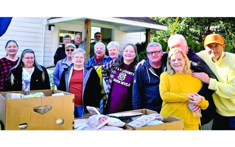SMT photo/Sara Eisinger.  Patty Ambrosino (front, left to right), Tami Millsap, Annette Hussan, Judy Hensley, Barbara Sherwood, Joan Parks, Angie Collins, Roger Millsap, Rita Filowick, Betty Spencer and “Hank”; (back, left to right) Ann Bullock, Dan Manley and Bill Helwig volunteer at Bryson City Food Pantry at its Presbyterian church location Wednesday, Feb. 26. Approximately 20 people volunteered at the pantry’s open outdoor market last week.