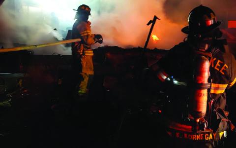 SMT photo/ Charles Bryson.  Fire crews extinguish a fire involving multiple trailers and vehicles on Ela Lane at approximately 12:30 a.m. Friday, Feb. 28. The second call came in a couple of hours later at a separate location with reports of people inside. 