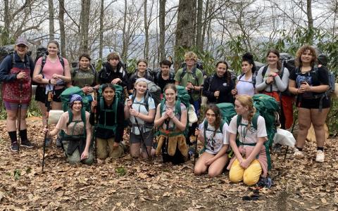 Submitted photo.  Mountain Discovery Charter School seventh grade students Rain (front, left to right), Mia, Maisy, Stella, Gaia and Alaina; (back, left to right) Aaliyah, Sara, Ryver, Trent, Novi, Nasseem, Miracle, Olivia, Vanessa, Olivia and Charlie take to the woods Wednesday, April 2, ending their excursion Friday, April 4. Approximately 150 field trips take place per year.