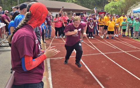 SMT photo/ Sara Eisigner.  Jayden Smiley cheers Swain High’s Nolan Griggs on during a race at the Special Olympics Far West Games in Bryson City Friday, April 25. Griggs is a graduating senior this year.