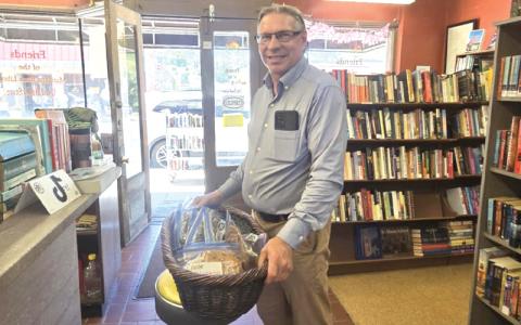 SMT photo/Sara Eisinger.  Pastor Kevin Linkinhoker with 12 varieties of peanut brittle to collect funds for church repairs after a large tree fell through its roof in January. 