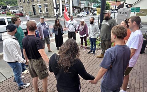 SMT photo/Sara Eisinger.   Remnant Restoration founders Michael and Rochelle Kramer lead a group of Christian missionaries in prayer on the corner of Mitchell and Everett streets Saturday, May 10. The couple will celebrate their five-year wedding anniversary May 28.
